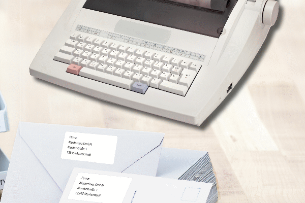Envelopes con etiquetas de dirección y una máquina de escribir