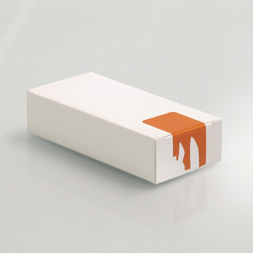 Weiße Faltschachtel mit orangefarbenem, zerstörtem Etikett auf der Seite, auf glattem Untergrund platziert.