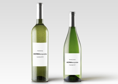 Zwei Flaschen Weißwein mit Etiketten: eine Chardonnay aus 2016 und eine Riesling aus 2017, beide mit dem Namen "HERMAexquisite".