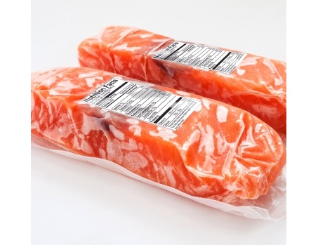 Zwei vakuumverpackte Lachsfilets mit Nährwertangaben auf den Etiketten.