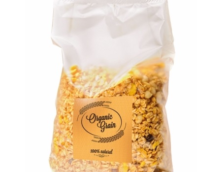 Eine durchsichtige Tüte mit Müsli, beschriftet mit "Organic Grain" und "100% natürlich". Die Mischung enthält verschiedene Getreidearten und Trockenfrüchte.