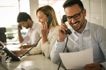 Drei Mitarbeitende telefonieren im Büro