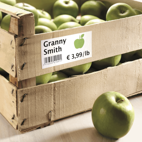 Grüne Granny Smith Äpfel in einer Holzkiste mit einem Preisschild von 3,99 € pro Pfund.