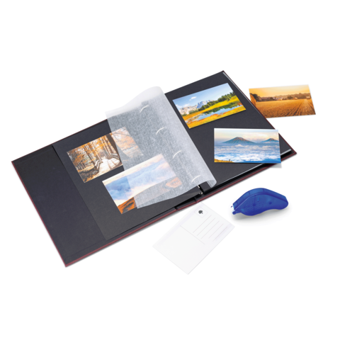 Ein offenes Fotoalbum mit mehreren Bildern, einer transparenten Schutzfolie und einem blauen Kleberoller daneben.