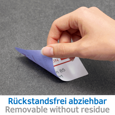 Eine Hand zieht einen ablösbaren Aufkleber von einer Oberfläche. Der Aufkleber zeigt den Text "Rückstandsfrei abziehbar" und "Removable without residue".