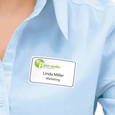 Ein Namensschild auf einer blauen Bluse zeigt den Namen "Linda Miller" und die Position "Marketing" für die Agentur Print Media.