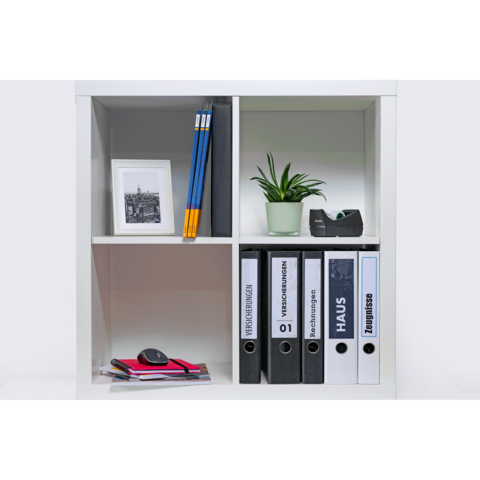 Ein Regal mit Ordnern, einem kleinen Pflanze, Bleistiften, einem Bildrahmen und Büromaterialien.