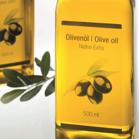Flasche mit Olivenöl, 500 ml, mit Etikett "Olivenöl | Olive oil, Native Extra" und einer Abbildung von Oliven und einem Olivenblatt.