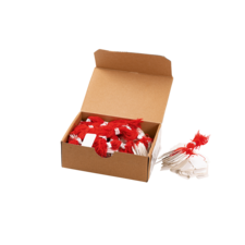 Eine offene Kartonbox mit roten und weißen Fäden, die ordentlich angeordnet sind, sowie einige leere Etiketten.