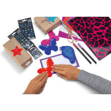 Hände gestalten bunte Schmetterlinge aus Papier, umgeben von Bastelmaterialien wie Geschenken, Stiften und Dekorationselementen.