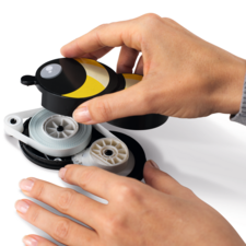 Una mano sostiene un dispensador amarillo y negro, mientras que otra mano tira del cordón.