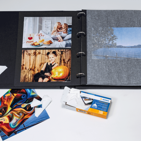 Un álbum de fotos con varias imágenes, incluyendo retratos y paisajes, así como algunas postales sueltas y un paquete de película.